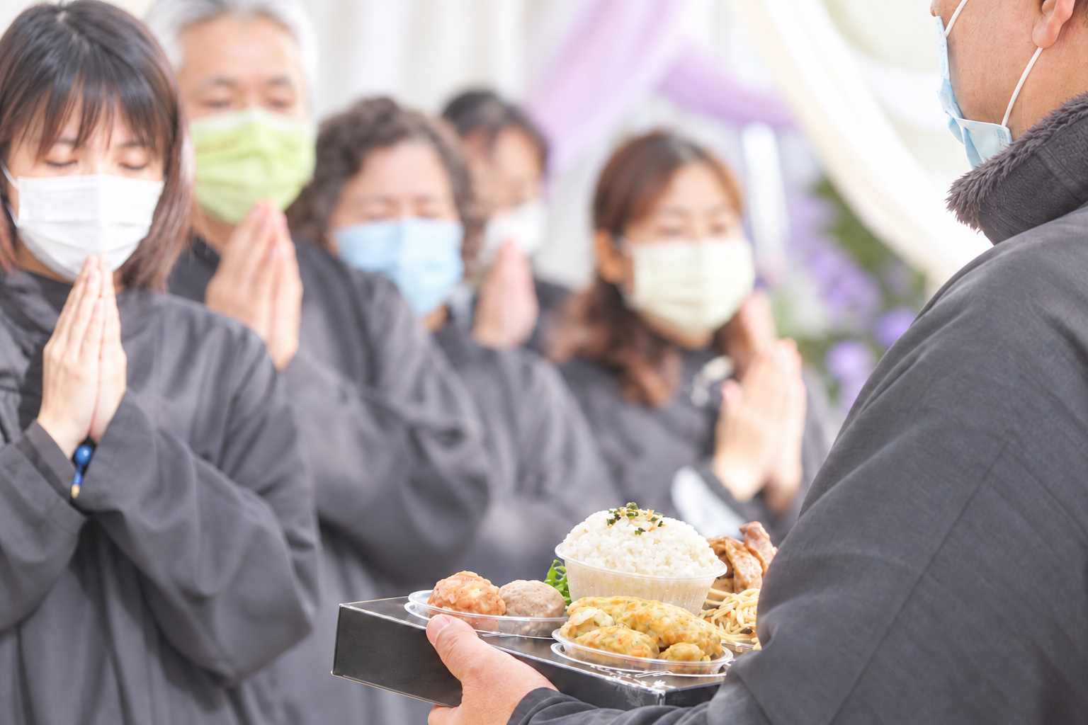 家屬雙手合十參與祭拜並準備供品